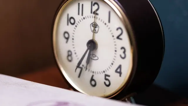 Close-up of an analogue alarm clock on a desk