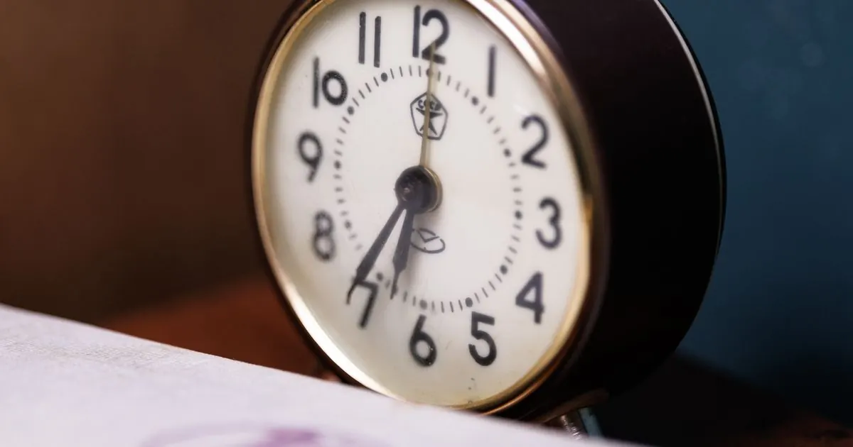 Close-up of an analogue alarm clock on a desk