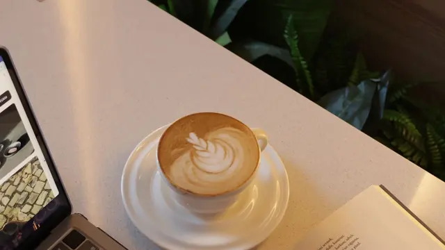 Latte on a minimalist desk next to a laptop