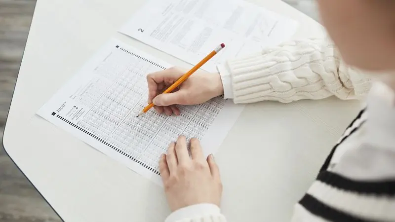 Student filling in an answer sheet with a pencil during a practice test